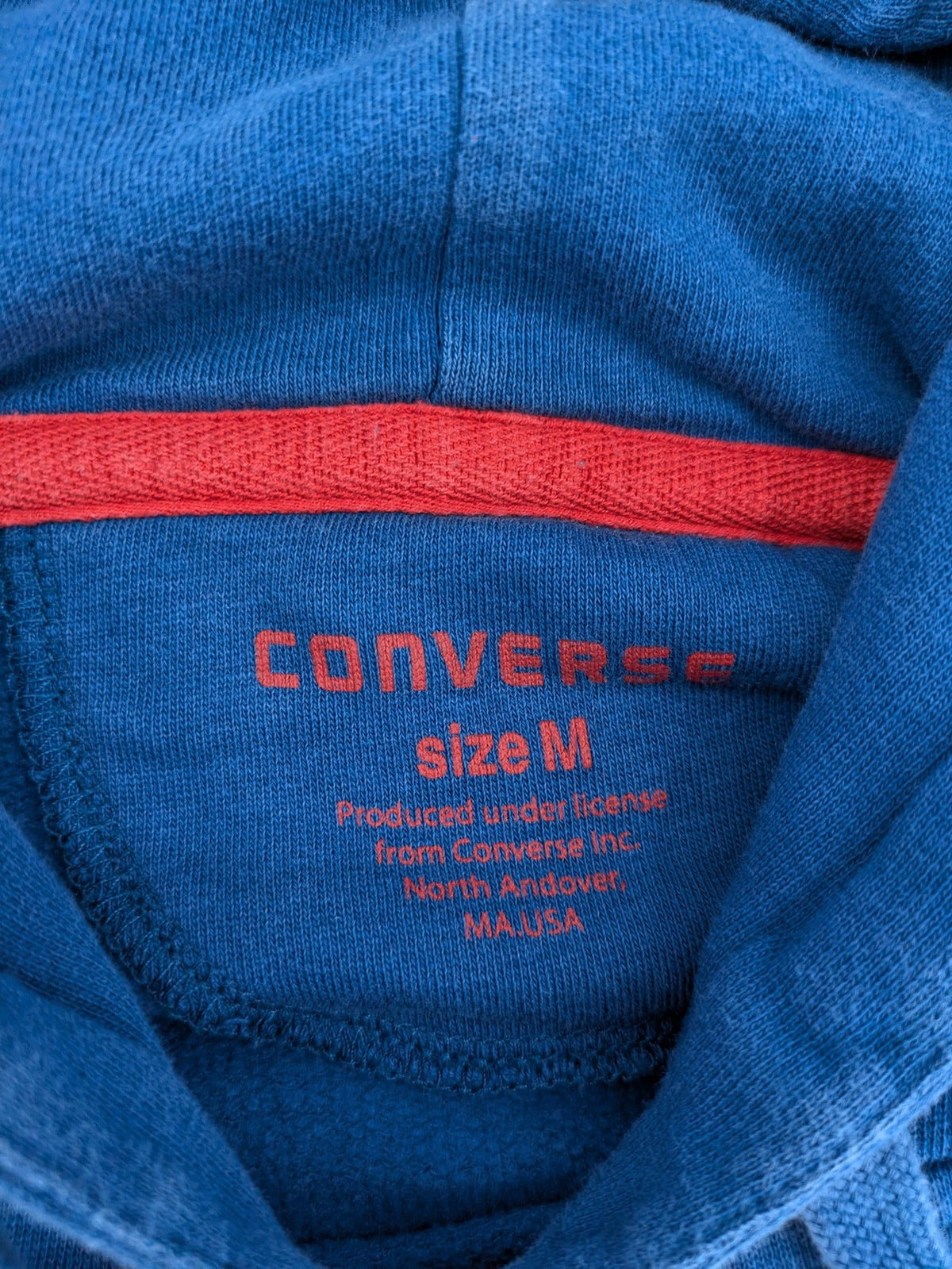 Converse All Star blue zip-through hoodie with red graphic logo and kangaroo pocket.