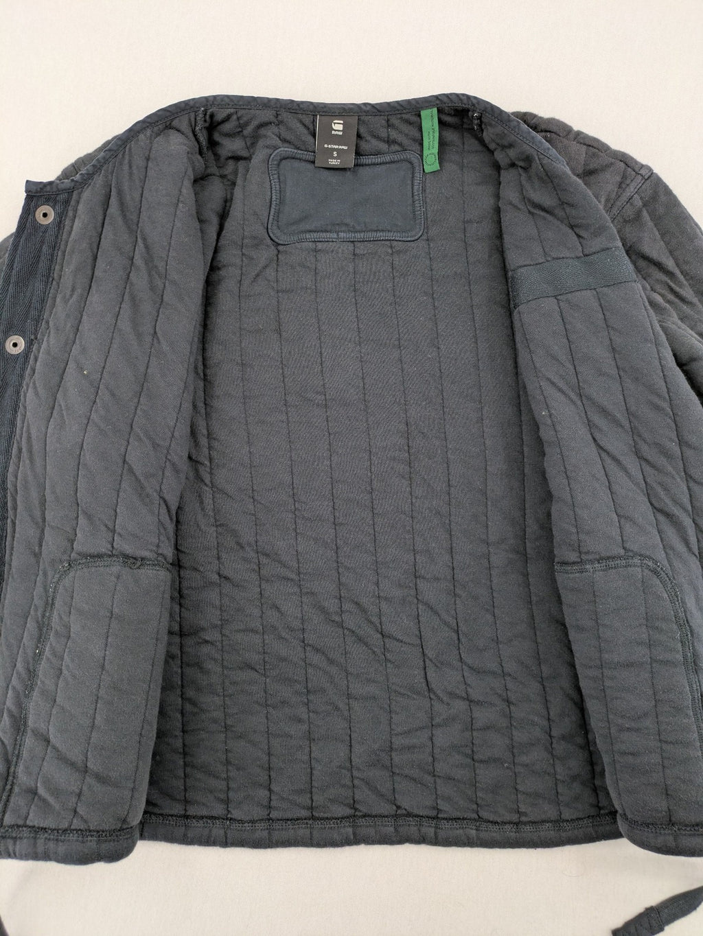 G-Star Raw grey quilted jacket with button closure and adjustable drawstring hem.