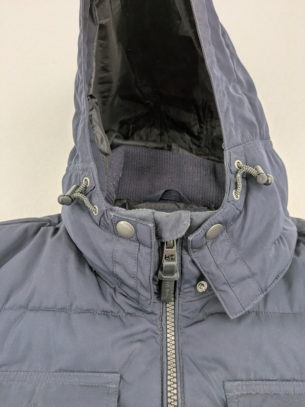Tom Tailor navy puffer jacket with quilted design and adjustable hood, featuring multiple pockets.