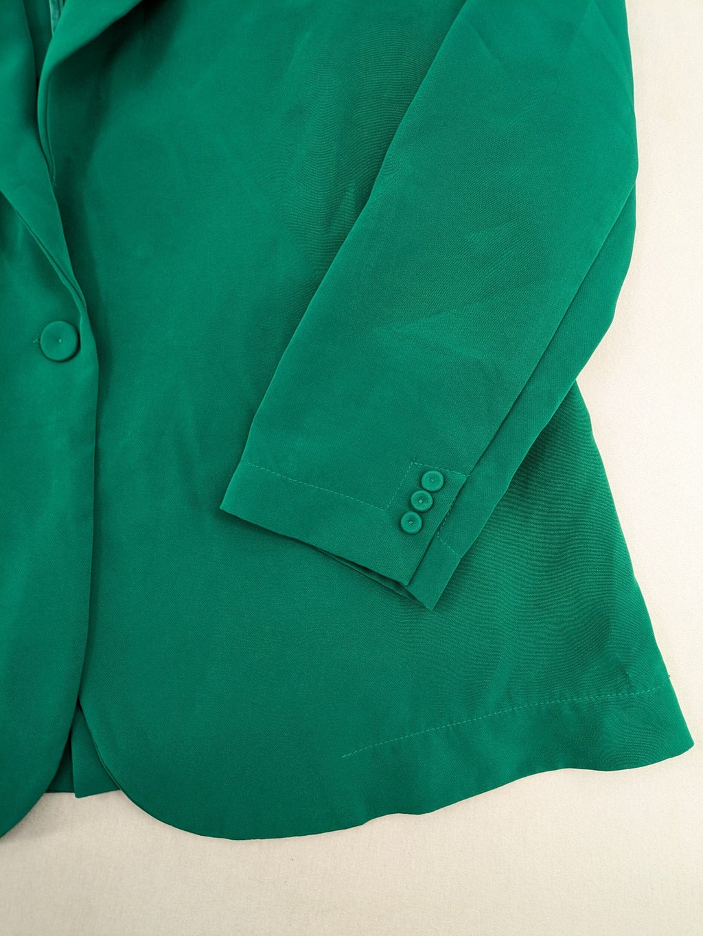 Promiss green blazer jacket single-button design with notch lapels and decorative pockets.