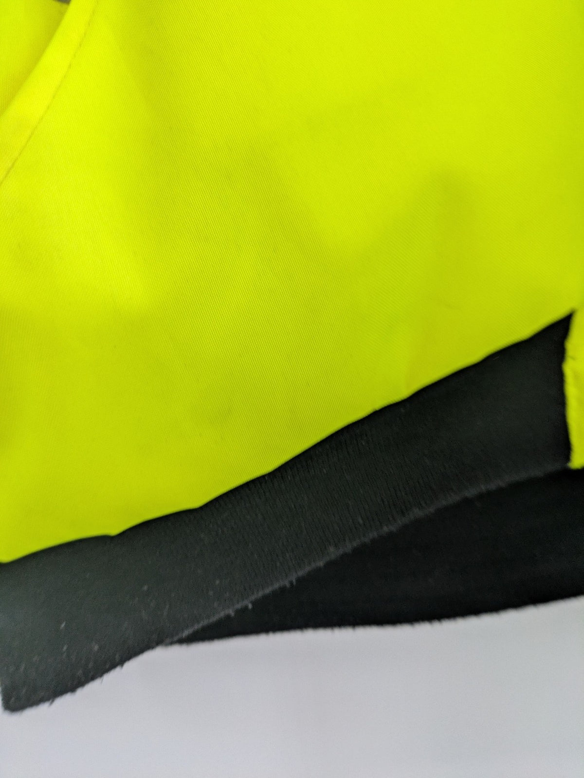 Hüren OHG grey and neon yellow safety jacket with reflective stripes and zippered arm pocket.