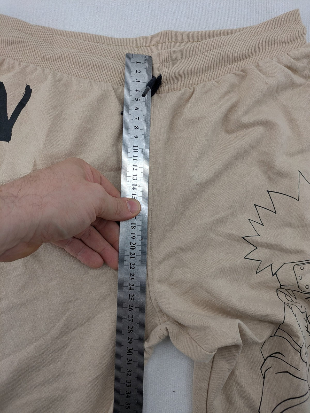 Naruto Shippuden beige joggers featuring Naruto Uzumaki graphic and logo print.