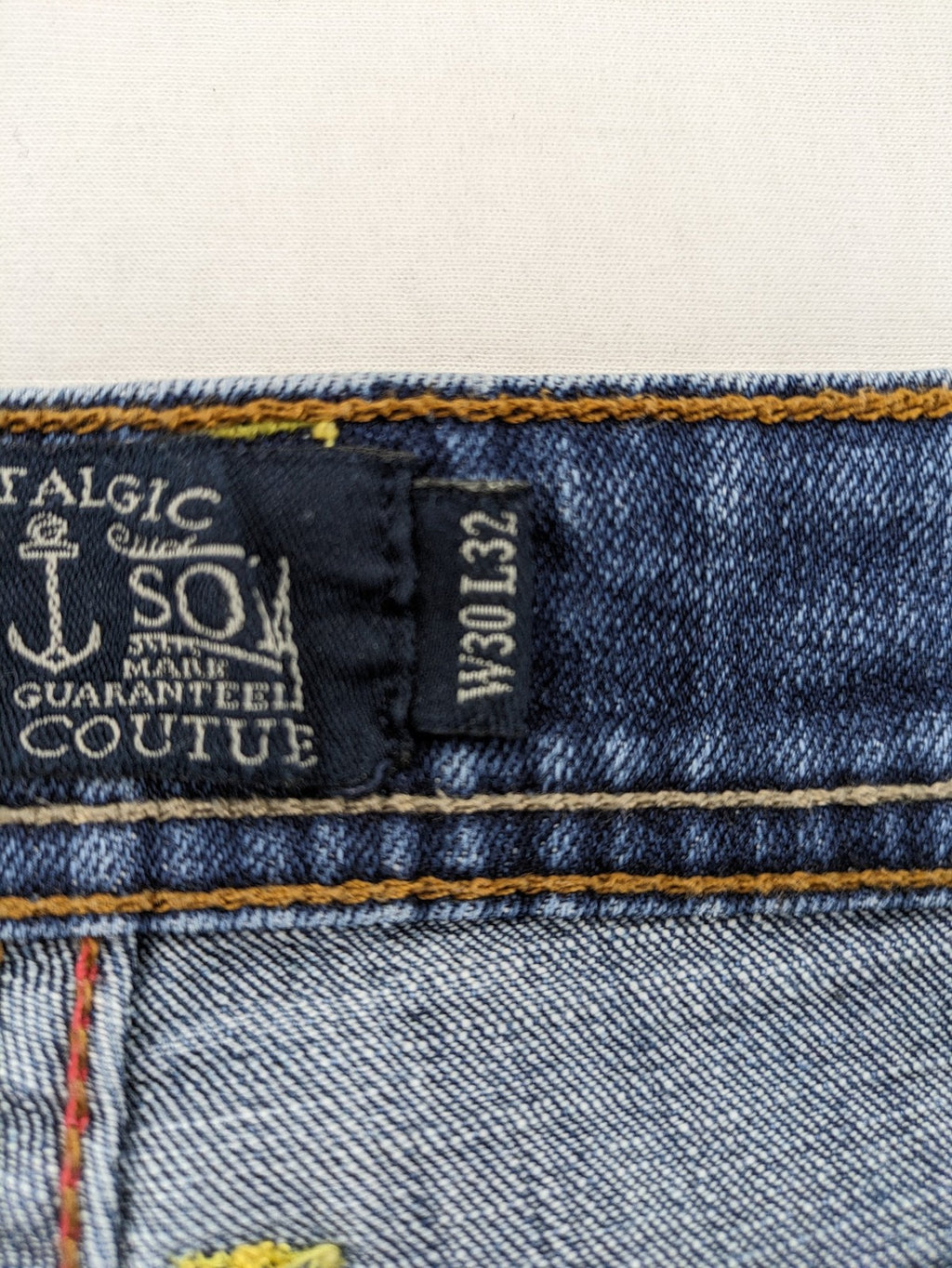 Soda blue straight jeans with distressed rips and button fly, cotton blend material.