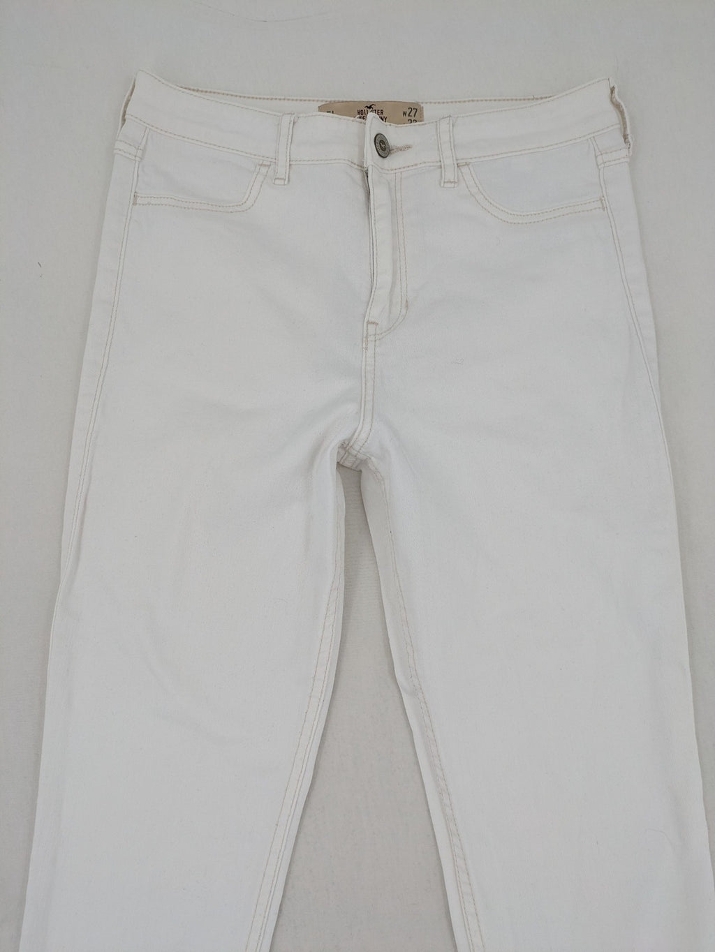 Hollister white super skinny high rise jeans with classic 5-pocket design and zipper closure.