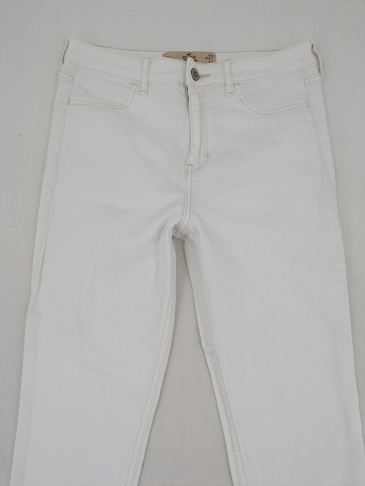 Hollister white super skinny high rise jeans with classic 5-pocket design and zipper closure.
