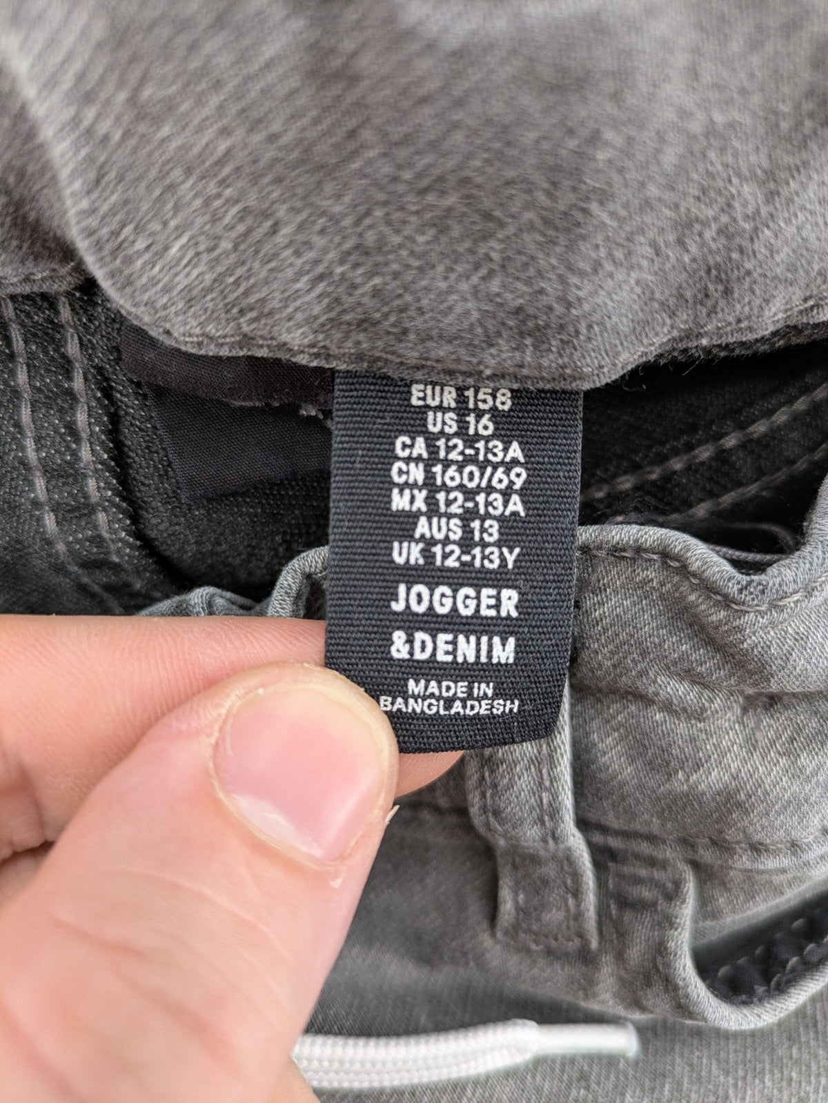 H&M grey jogger jeans with elastic waistband and drawstring, stylish washed look.