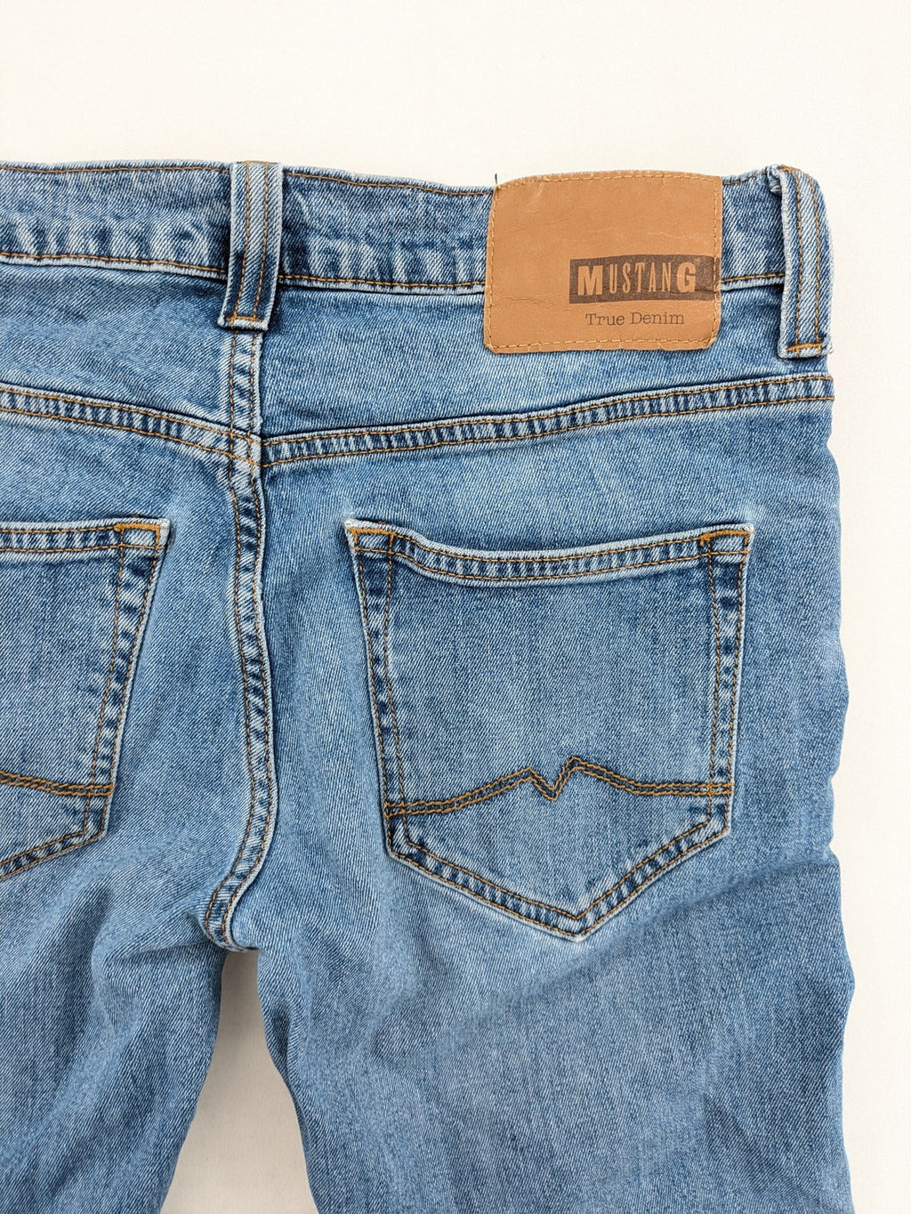 Mustang blue straight jeans with classic wash and durable denim material.