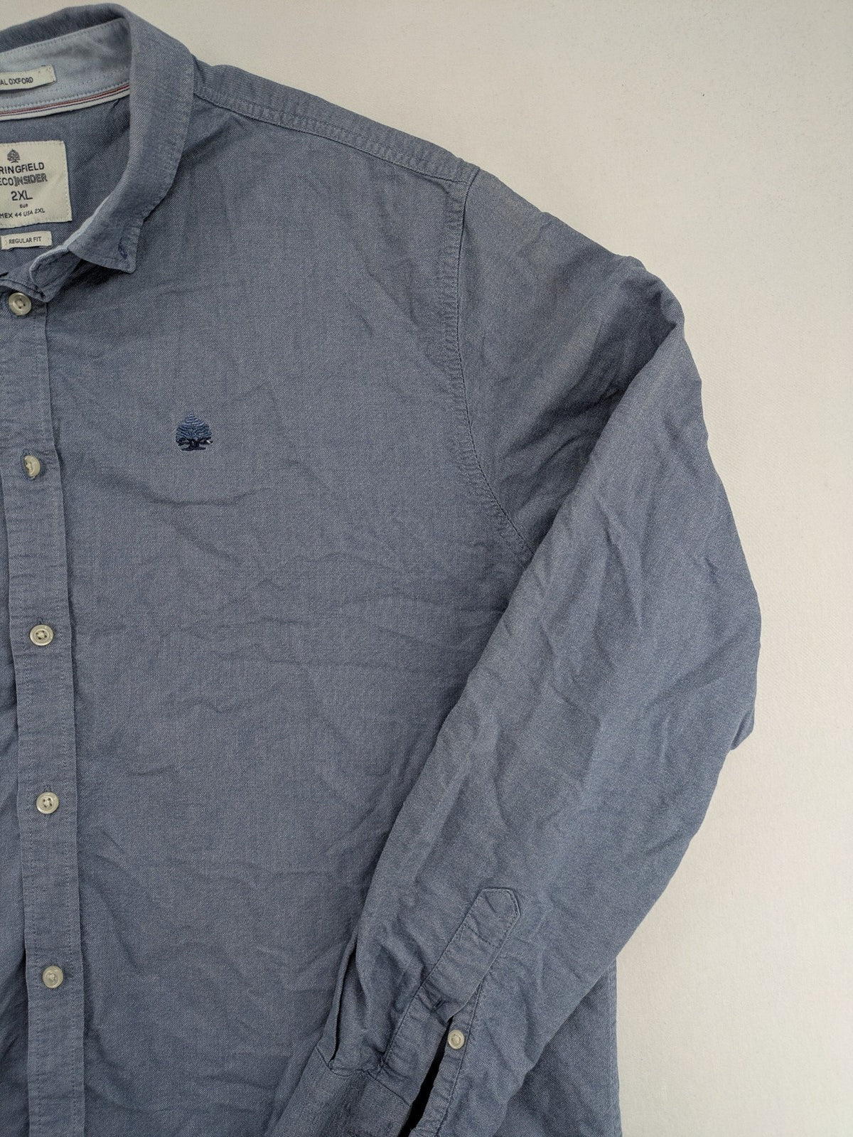 Springfield blue Oxford shirt with button placket and subtle logo embroidery.