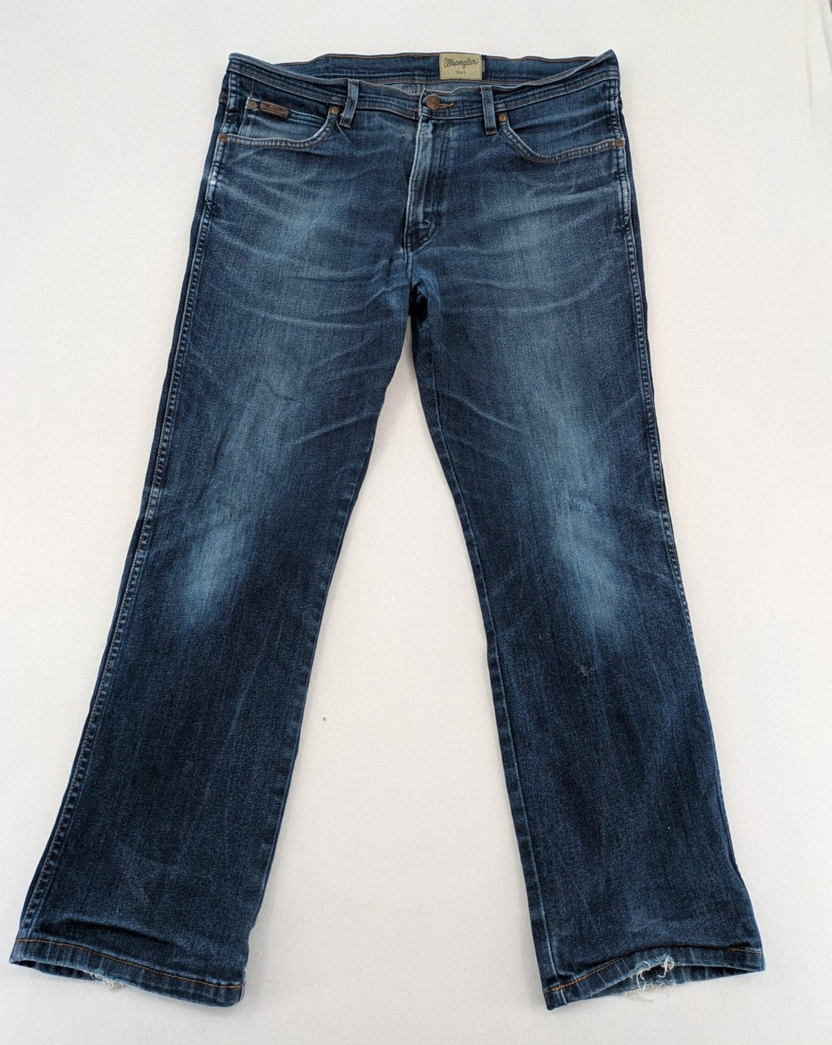 Wrangler straight jeans blue with iconic "W" stitching on back pockets.