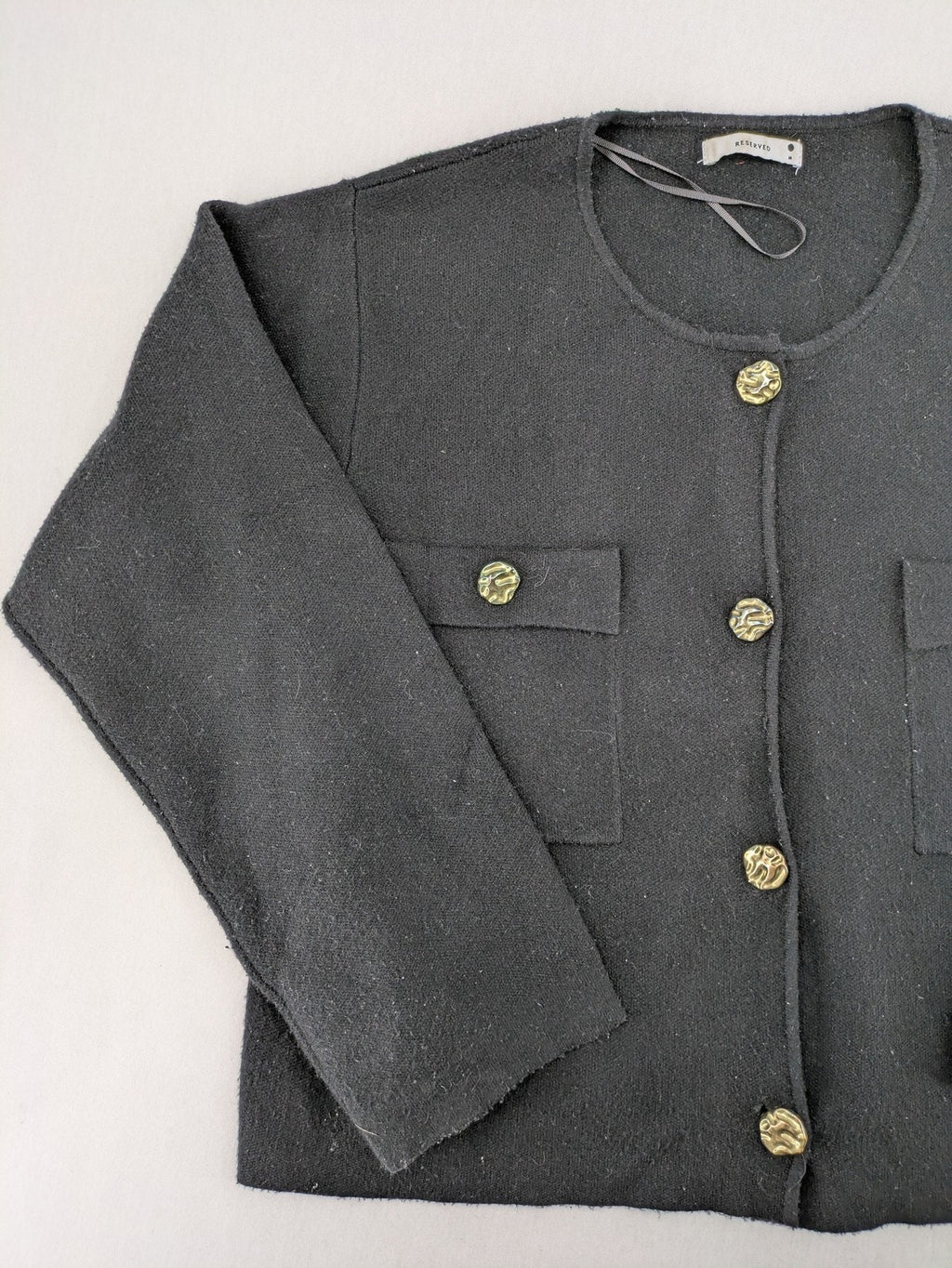 Reserved gold turtle neck jumper with black knit, gold button details and front pockets.