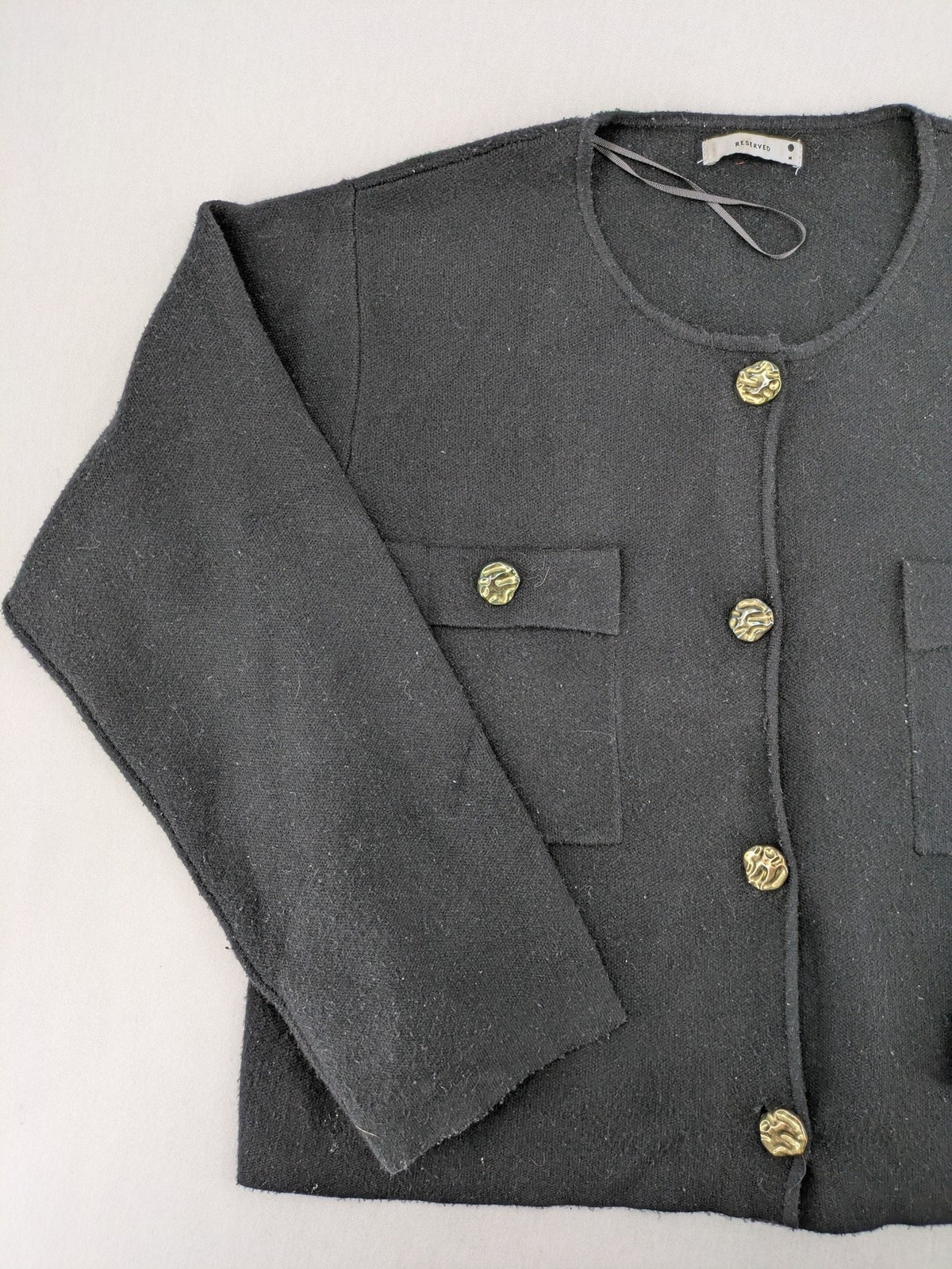 Reserved gold turtle neck jumper with black knit, gold button details and front pockets.