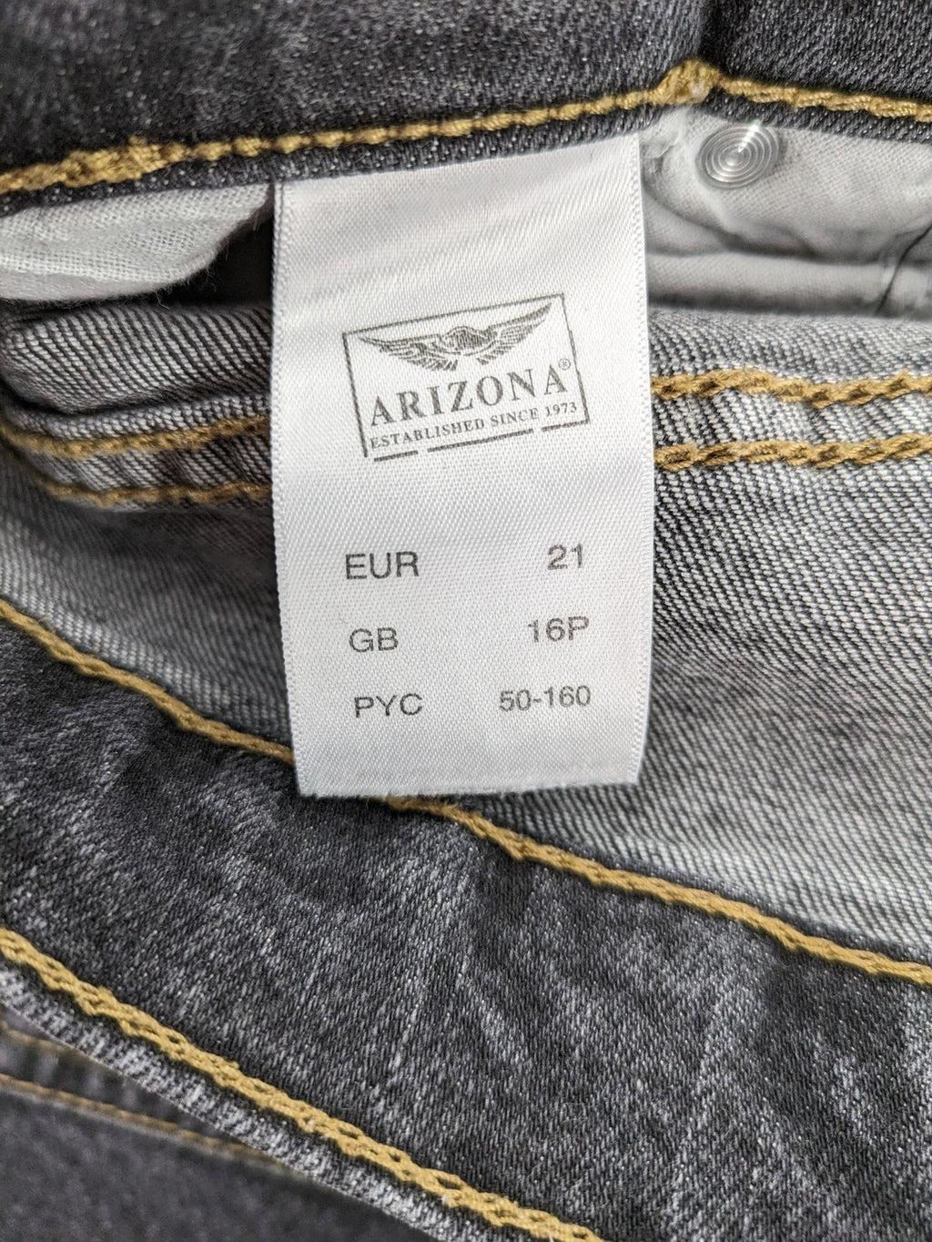Bootcut grey low rise bootcut jeans five-pocket design with zipper and button closure.