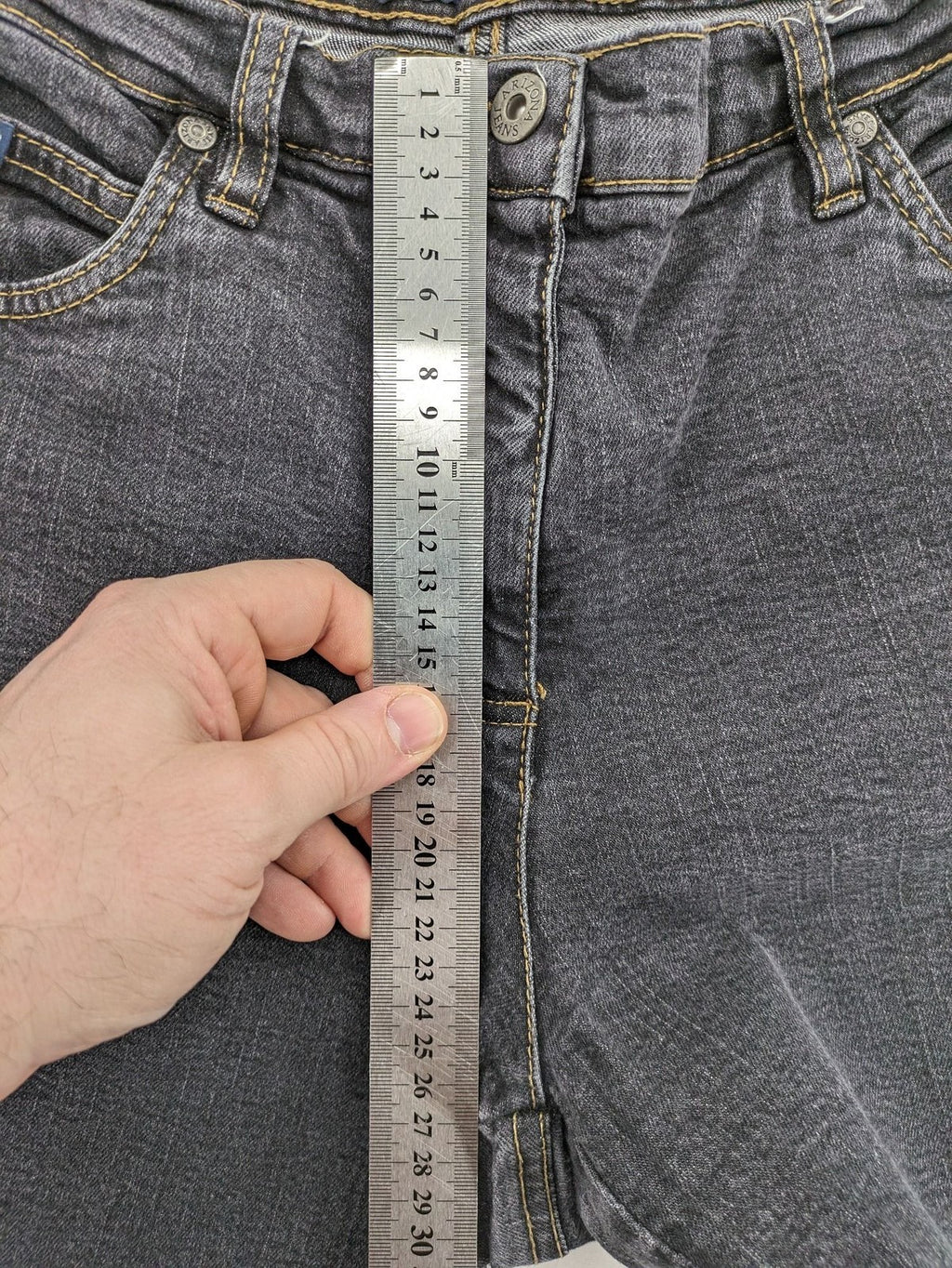 Bootcut grey low rise bootcut jeans five-pocket design with zipper and button closure.