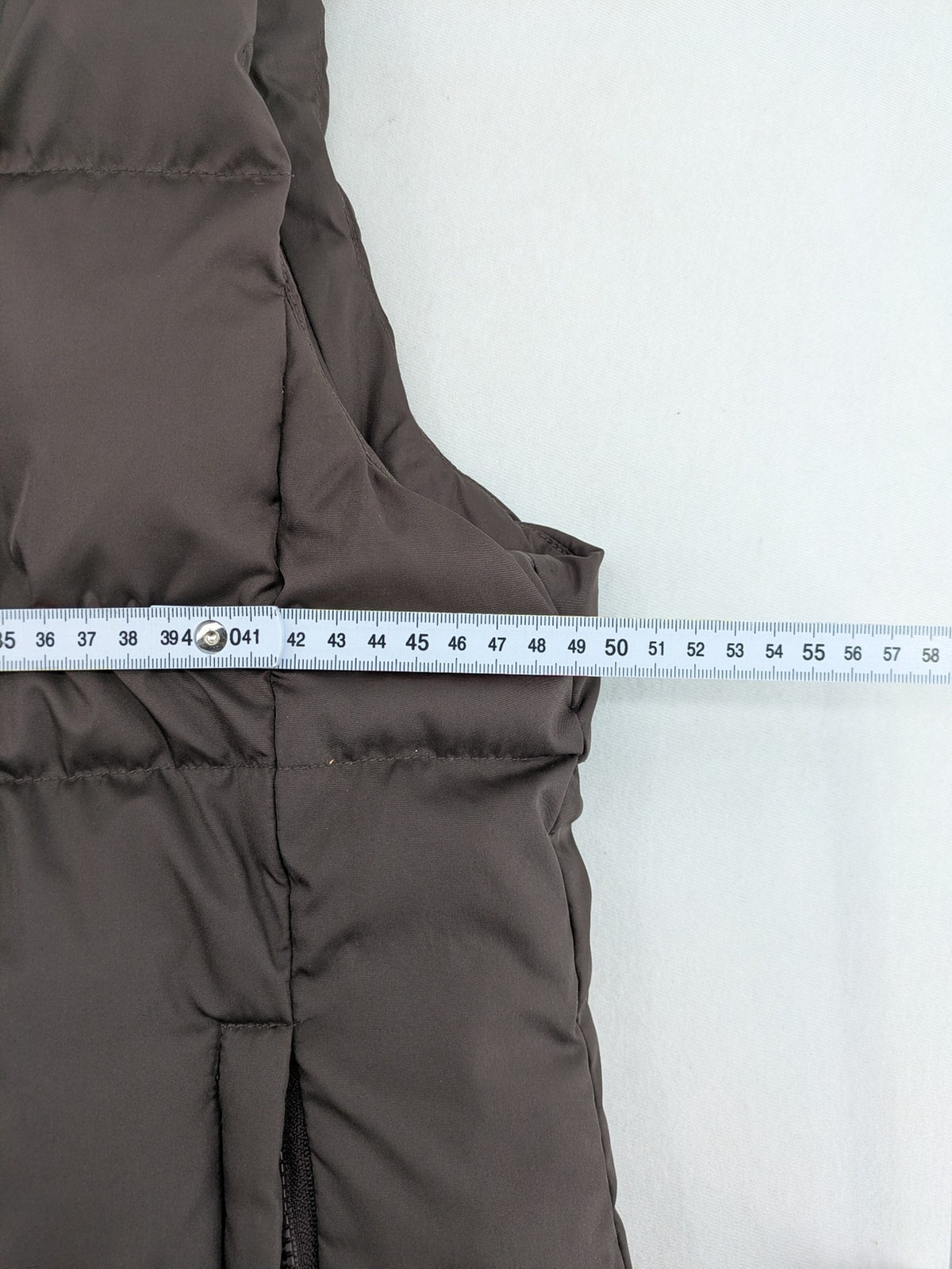 Esprit brown puffer vest with high ribbed collar and zip button closure.