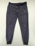 Nike F.C. grey jogger pants with elastic waistband, side pockets, and embroidered Swoosh logo.