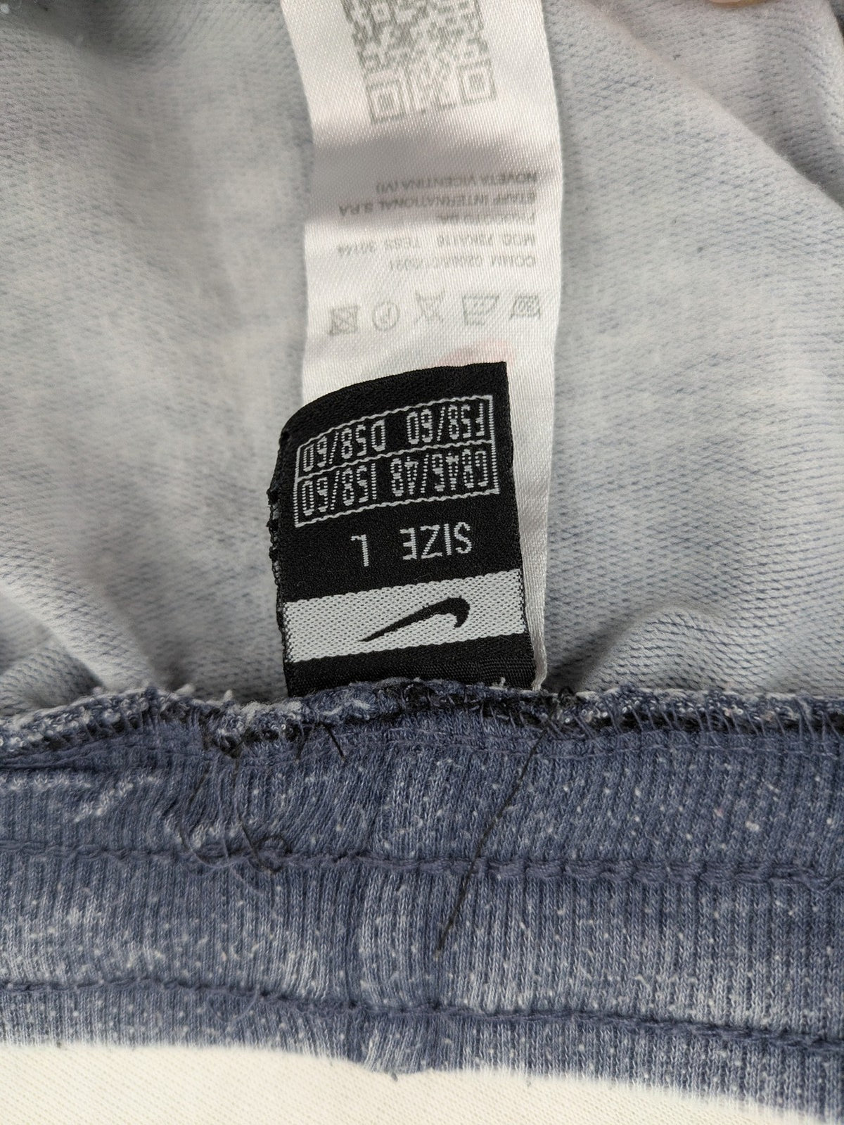 Nike grey acid wash jogger shorts with embossed logo and zip pockets.