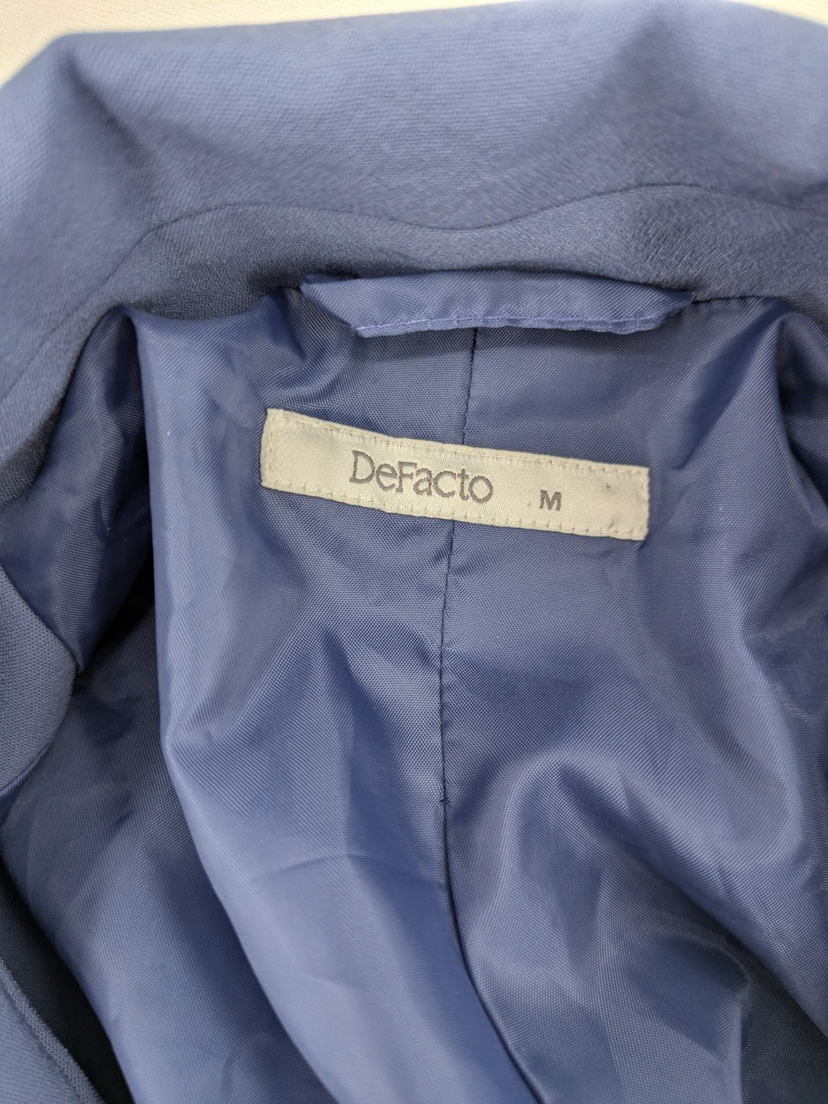 DeFacto blue trench coat with classic lapels and matching self-tie belt.