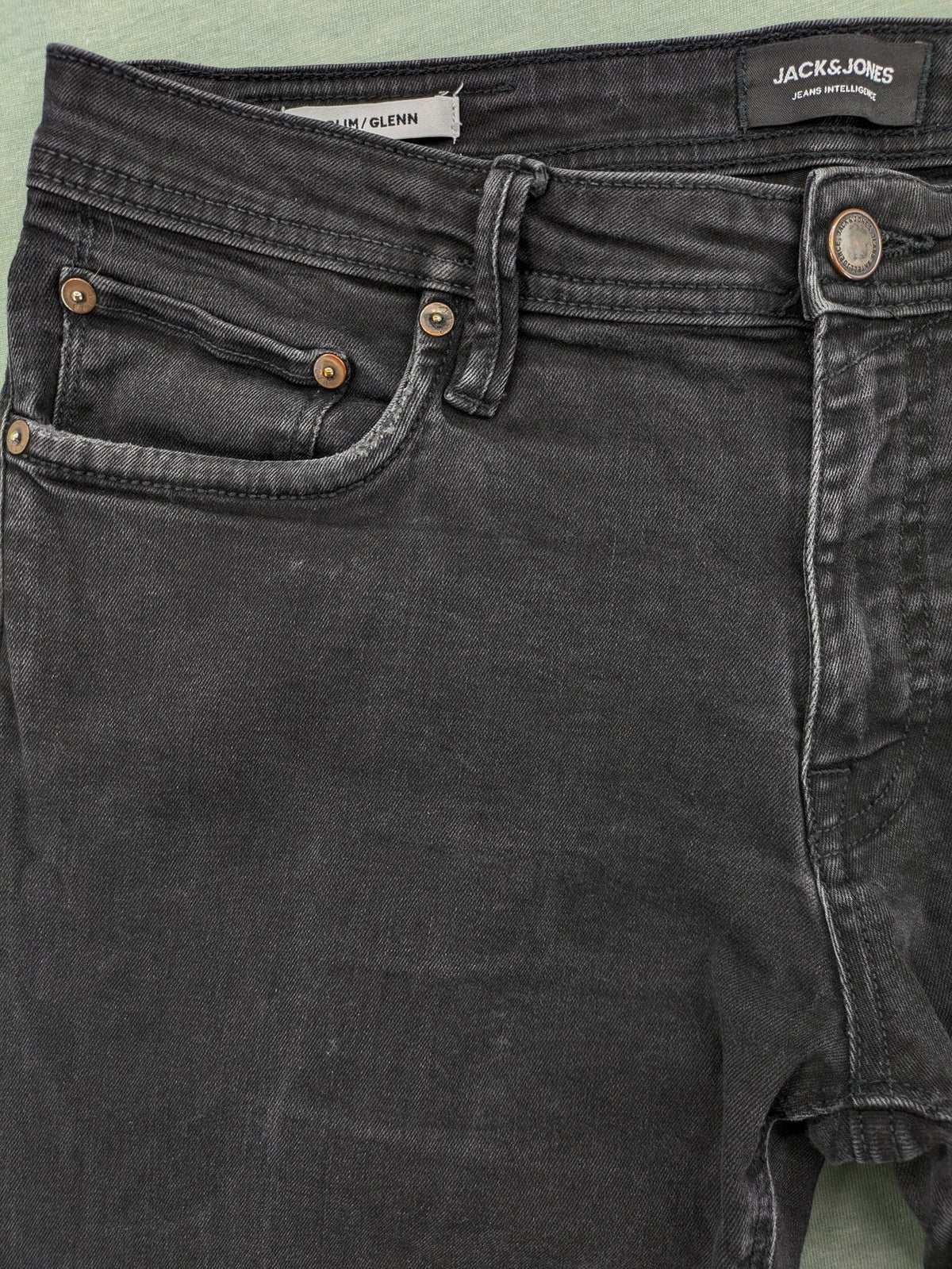 Jack & Jones black slim fit jeans faded wash stretch denim with logo detail.