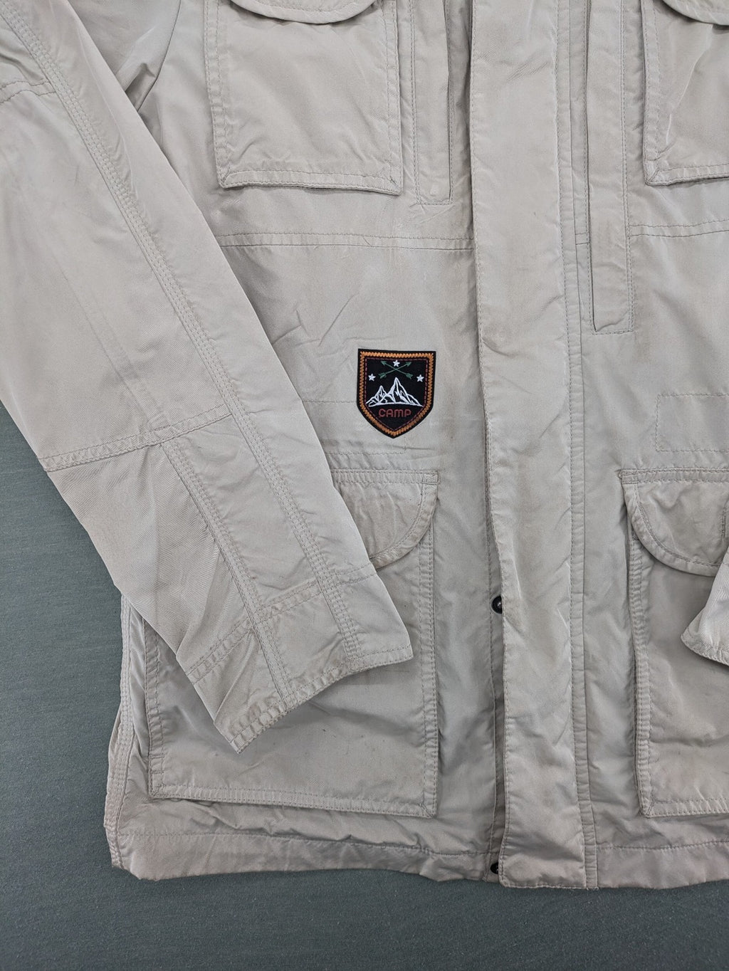 Camp David beige field jacket with logo patches, standing collar, and multiple pockets.