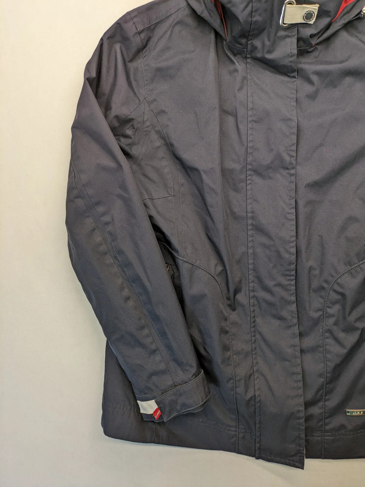 WPF grey outdoor jacket with red lining, zip closure, and hood.