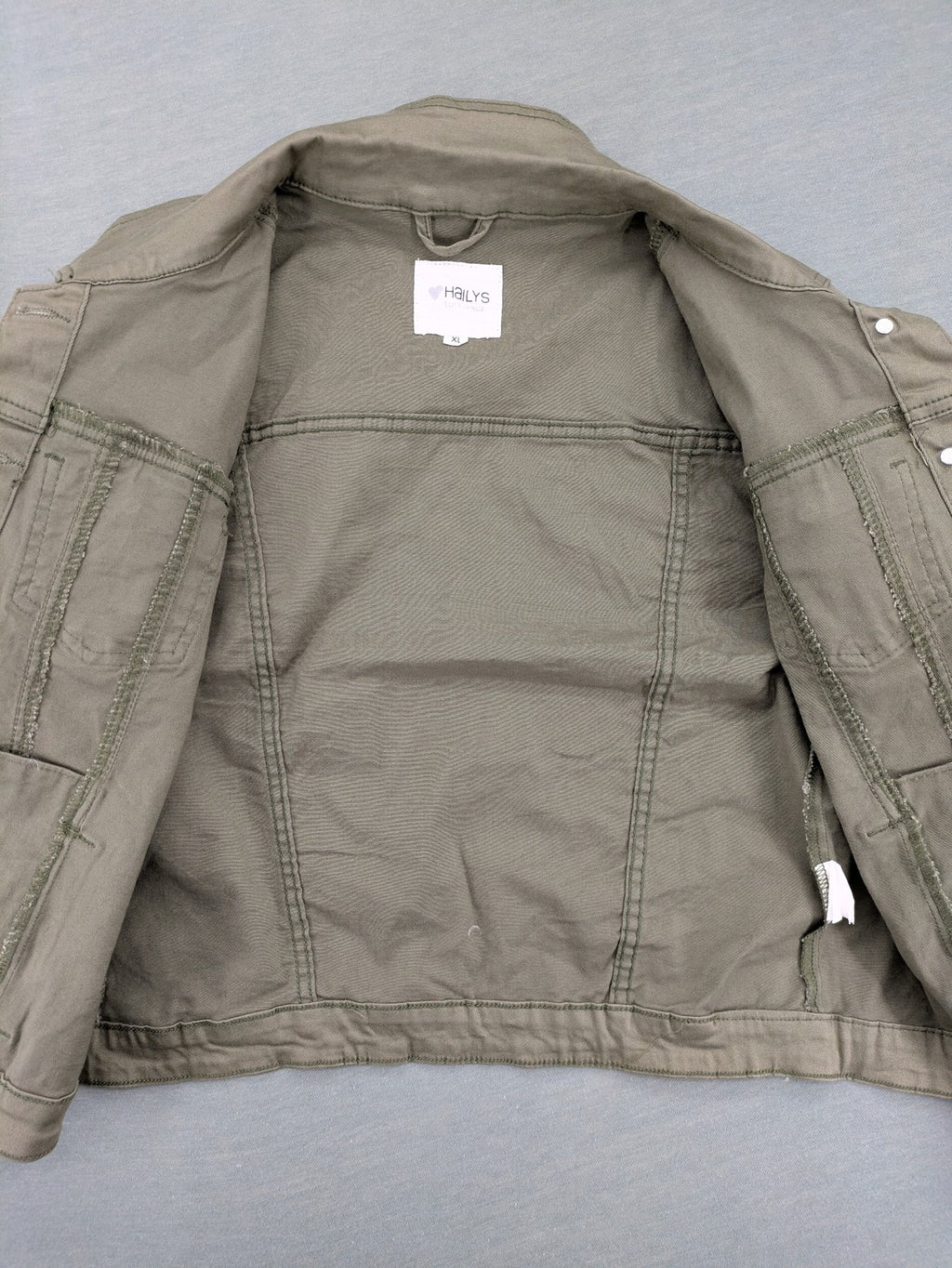 Hailys khaki denim jacket with button closure, two chest pockets, and side pockets.