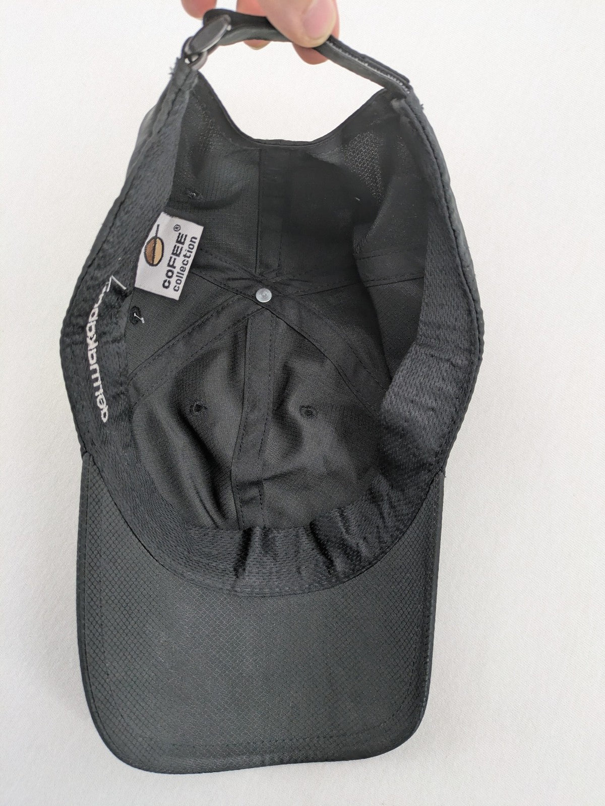 Funktional grey baseball cap with embroidered Dormakaba logo and modern ripstop texture.