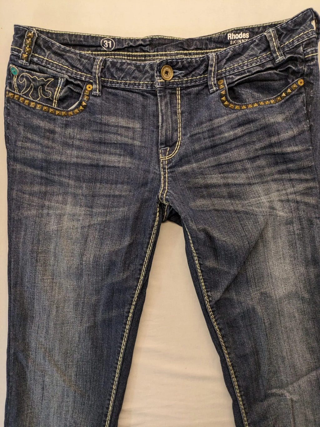 Rhodes blue skinny jeans with decorative studs and intricate embroidery on back pockets.