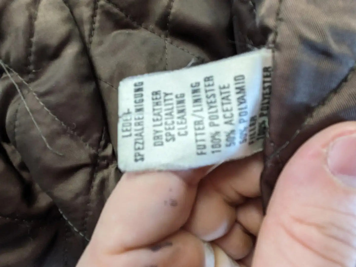 Vintage brown leather jacket with graphic lining, zip closure, and button placket.