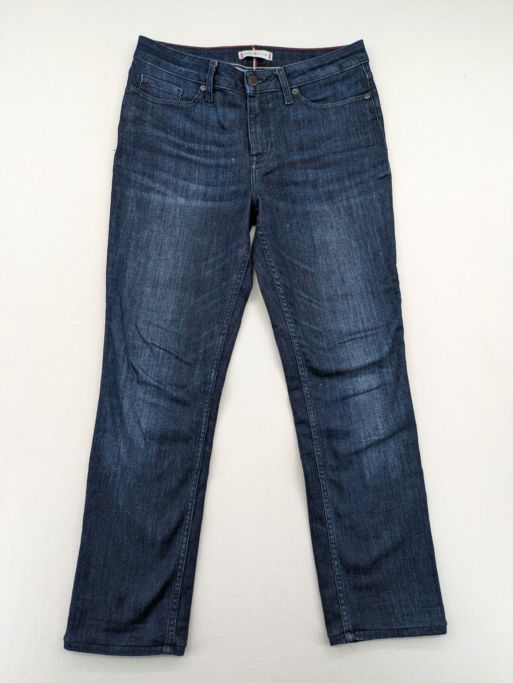 Tommy Hilfiger blue straight jeans with iconic logo and dark wash denim finish.