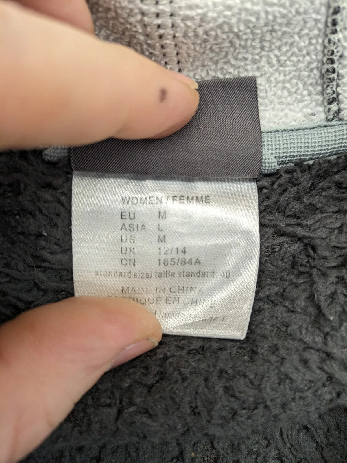 Jack Wolfskin grey fleece jacket with logo detailing and two front pockets.