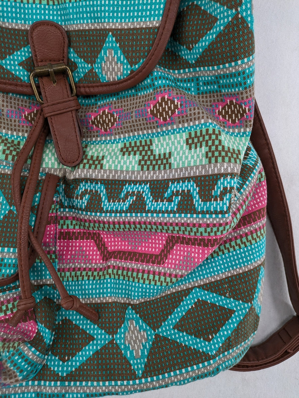 Boho multi backpack with vibrant Aztec tribal print and brown faux leather accents.