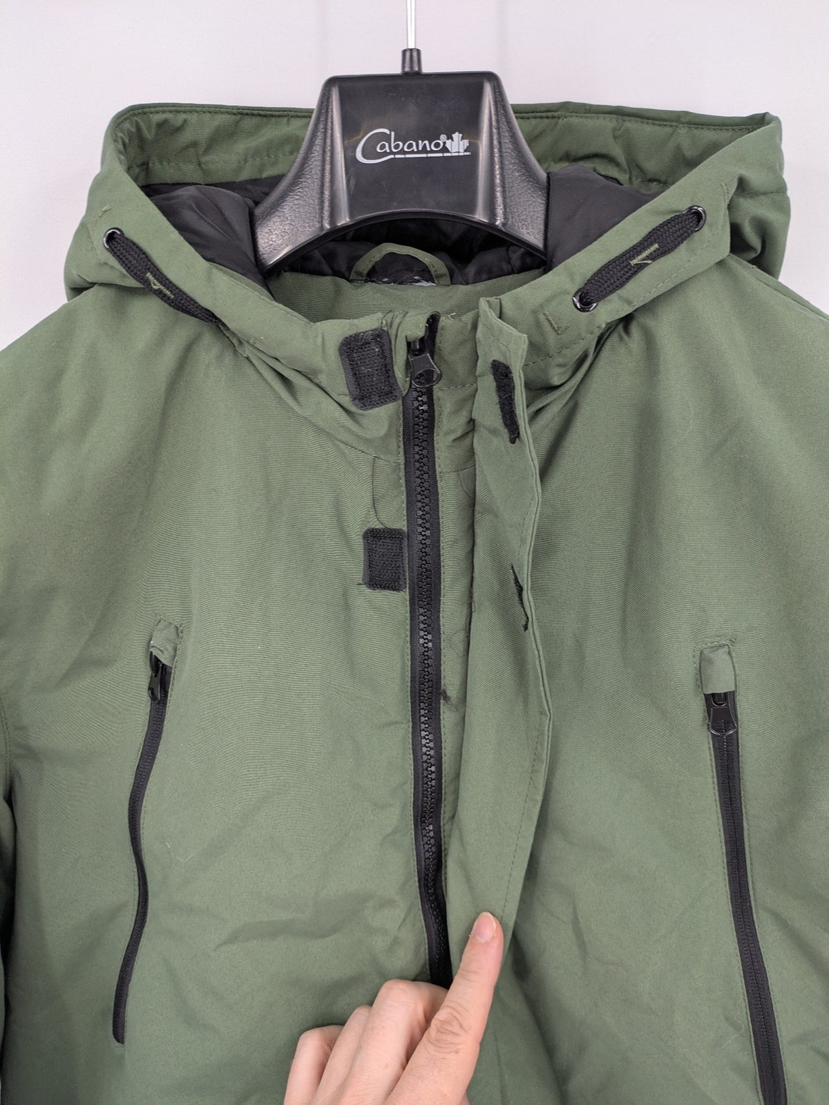 Bad Choices green parka coat with reflective details and logo patch on sleeve.
