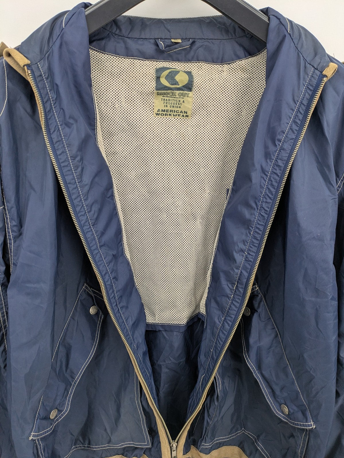 Knock Out navy blue jacket full zip nylon with brown accents and breathable mesh lining.