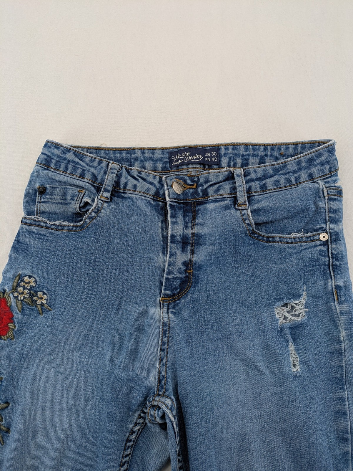 Jennyfer pink skinny jeans with distressed details and red rose embroidery on hips and knees.