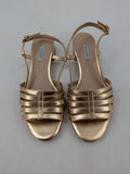 Office London gold metallic sandals with adjustable ankle strap and block heel design.