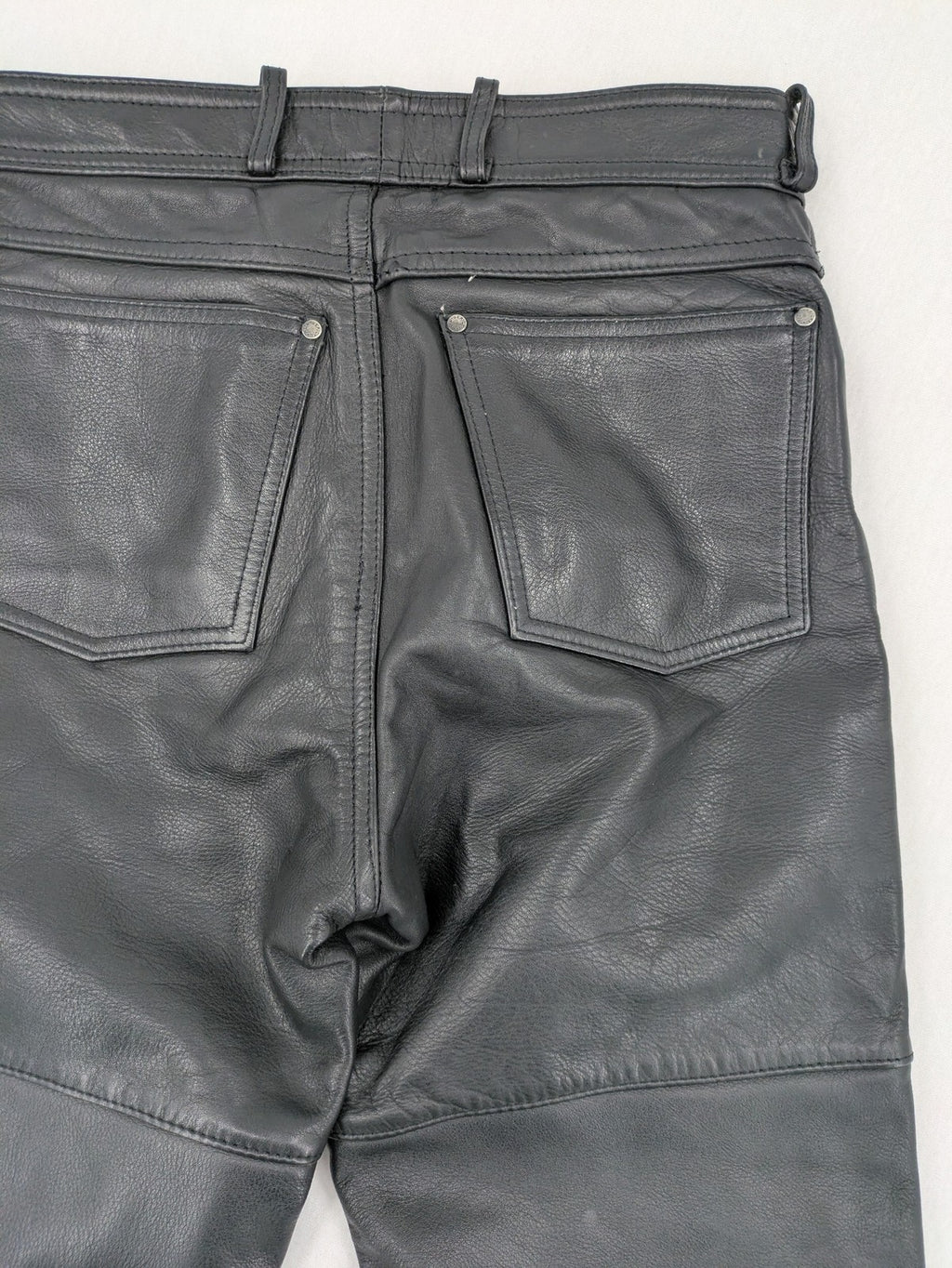 Hein Gericke black leather chaps with studs and wavy decorative seams.