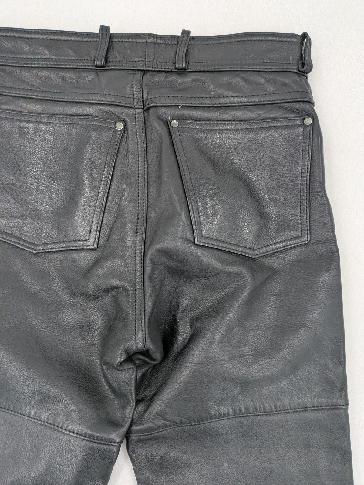 Hein Gericke black leather chaps with studs and wavy decorative seams.