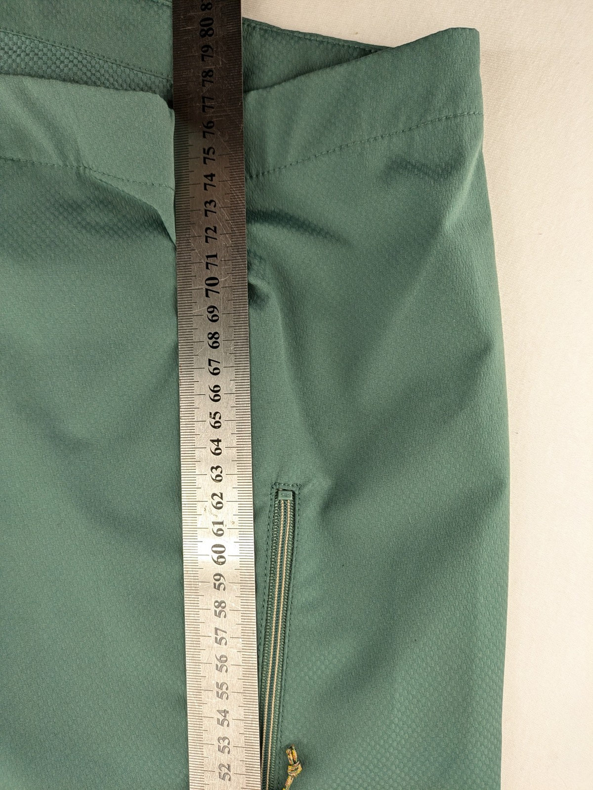 Frilufts green softshell jacket with hood, longline design, durable zipper, practical zip pockets.