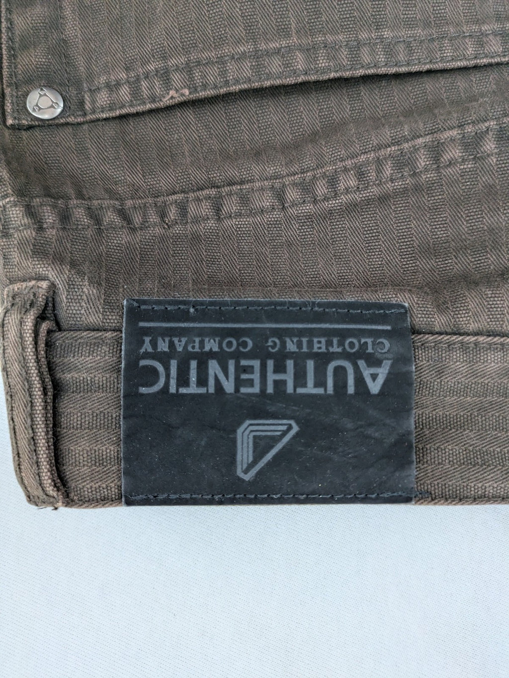 Authentic Clothing Company brown straight jeans with subtle stripe pattern and brand patch.