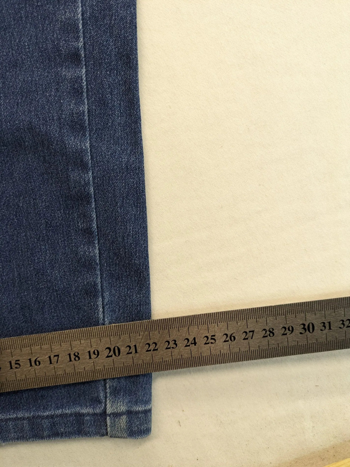 REI blue straight jeans with front pleats, zip fly, and buttoned back pockets.