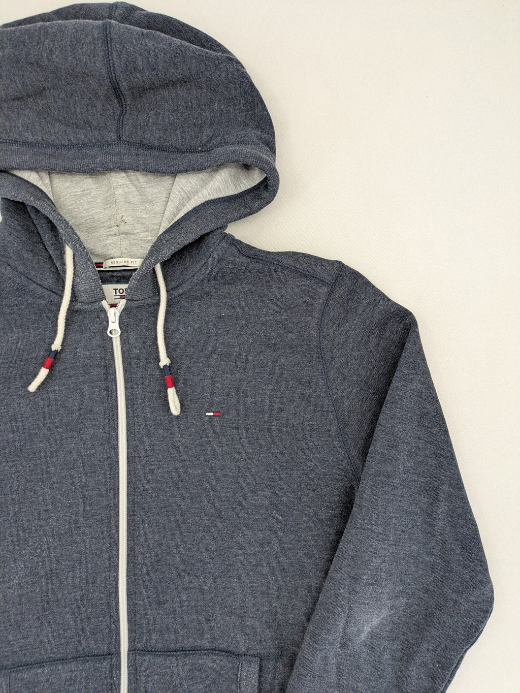 Tommy Jeans blue full zip hoodie with logo, adjustable hood, and kangaroo pockets.