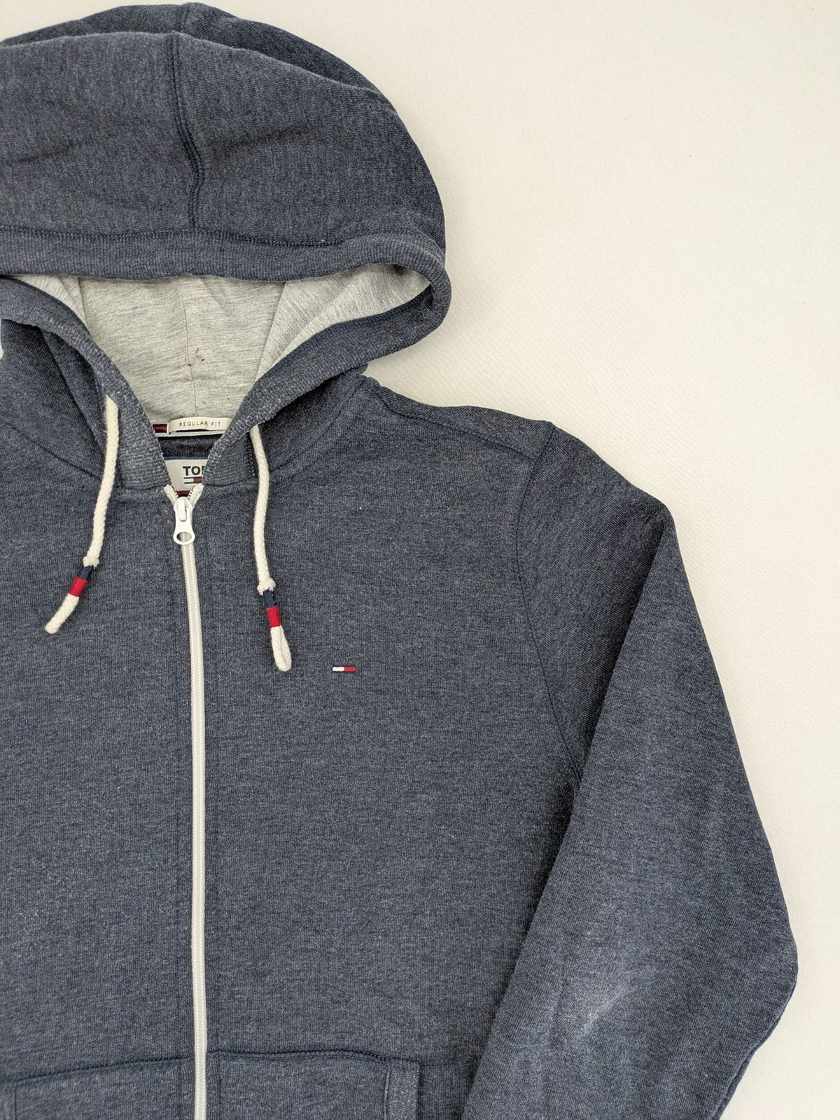 Tommy Jeans blue full zip hoodie with logo, adjustable hood, and kangaroo pockets.