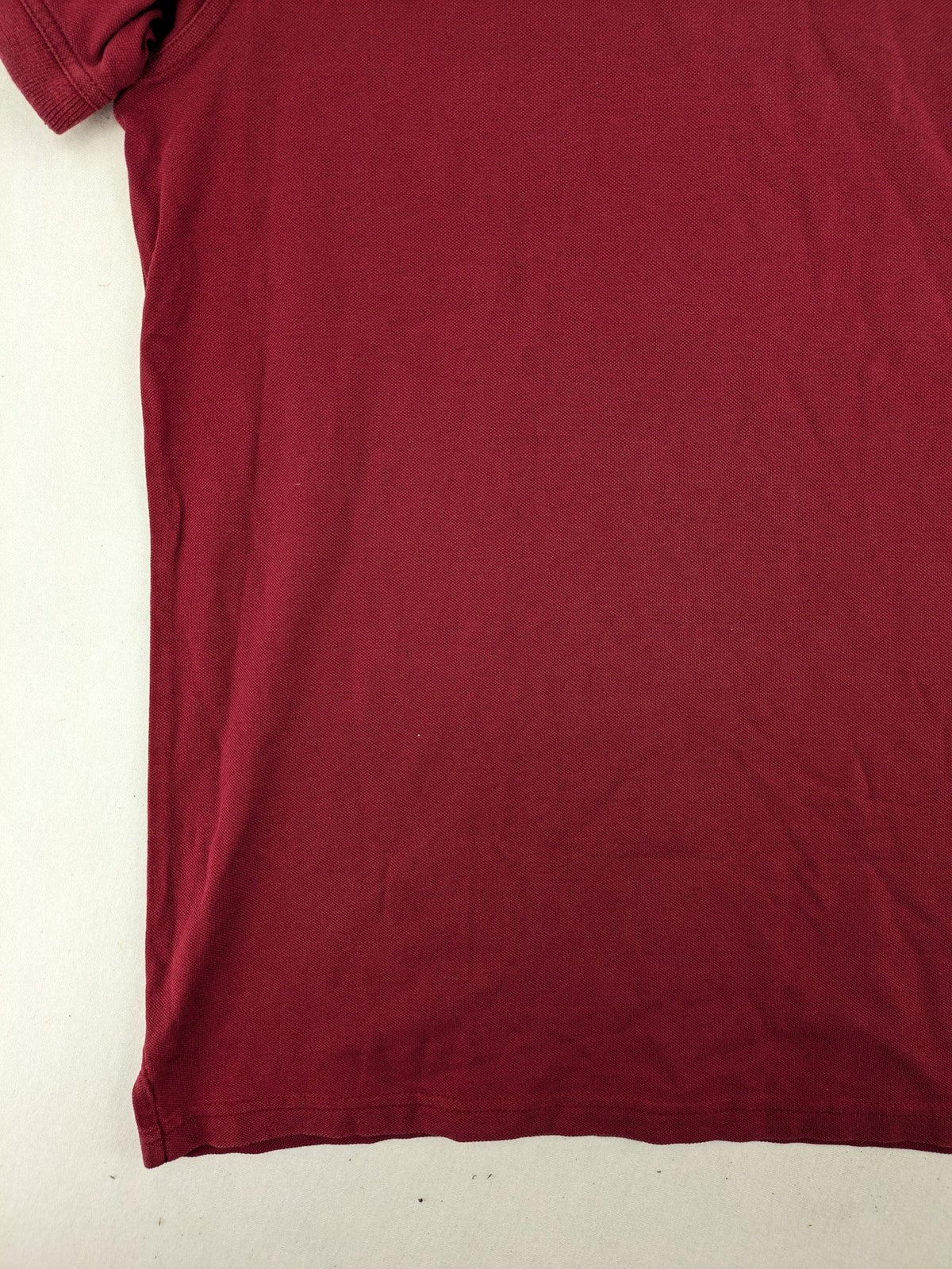 GANT burgundy polo shirt with embroidered shield logo and contrasting navy collar details.