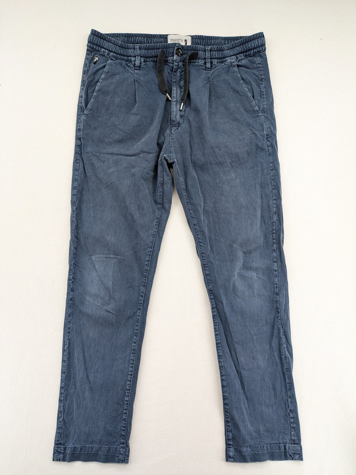 Spaghetti Mafia cream pants with elastic waistband, drawstring, and subtle front pleats.