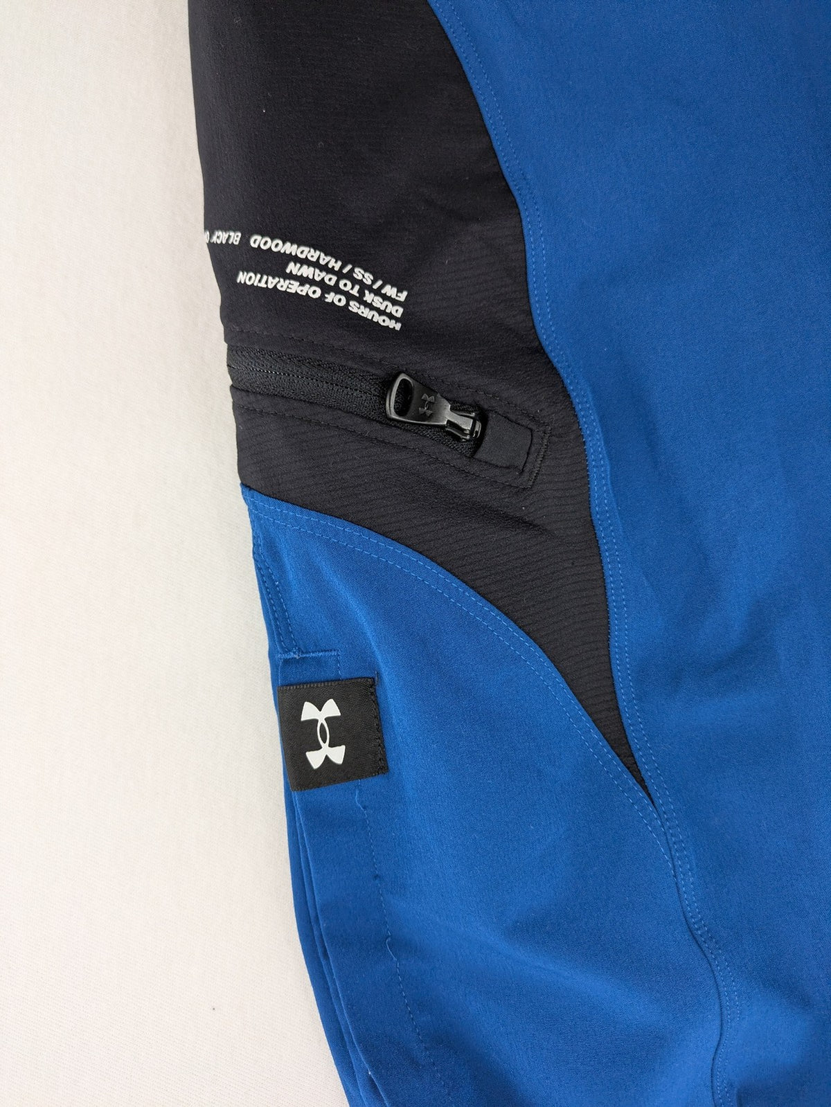 Under Armour blue HeatGear joggers with black accents and zippered cargo pockets.