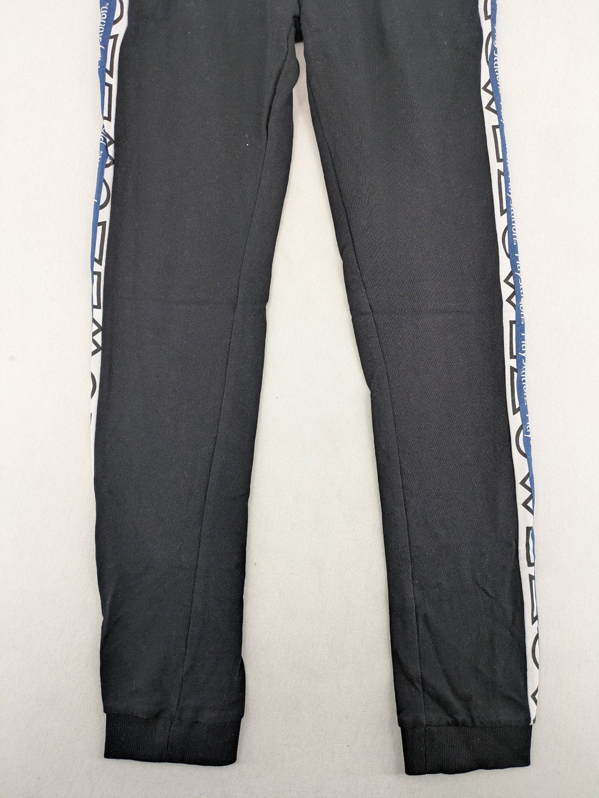 Baumwolle black pants with PlayStation logo tape, elastic waistband, cotton material.