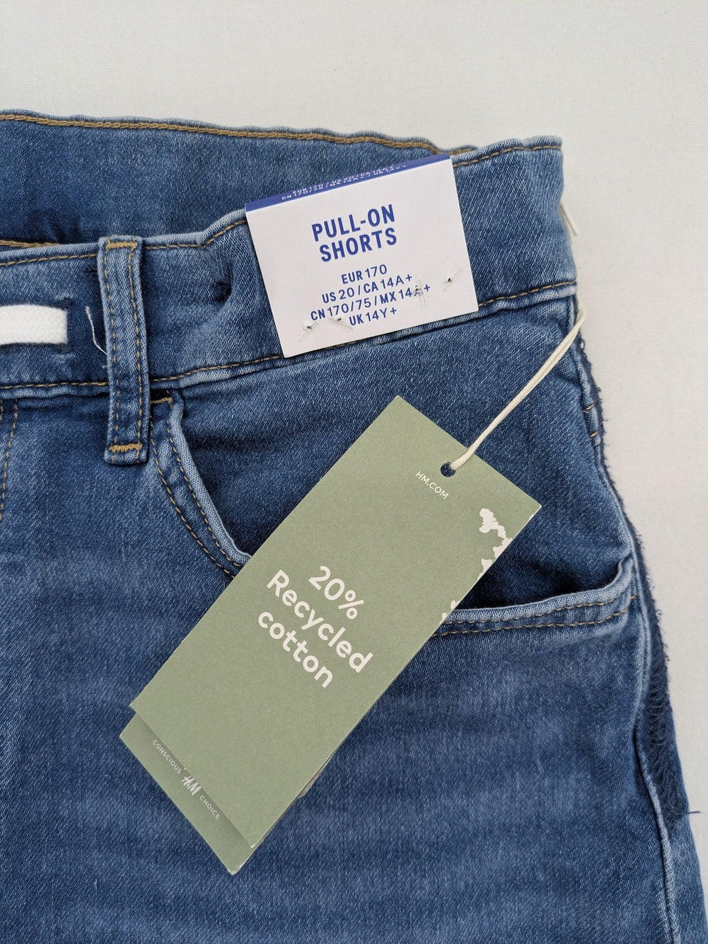 H&M blue denim shorts with adjustable drawstring, rolled hem, classic 5-pocket design.