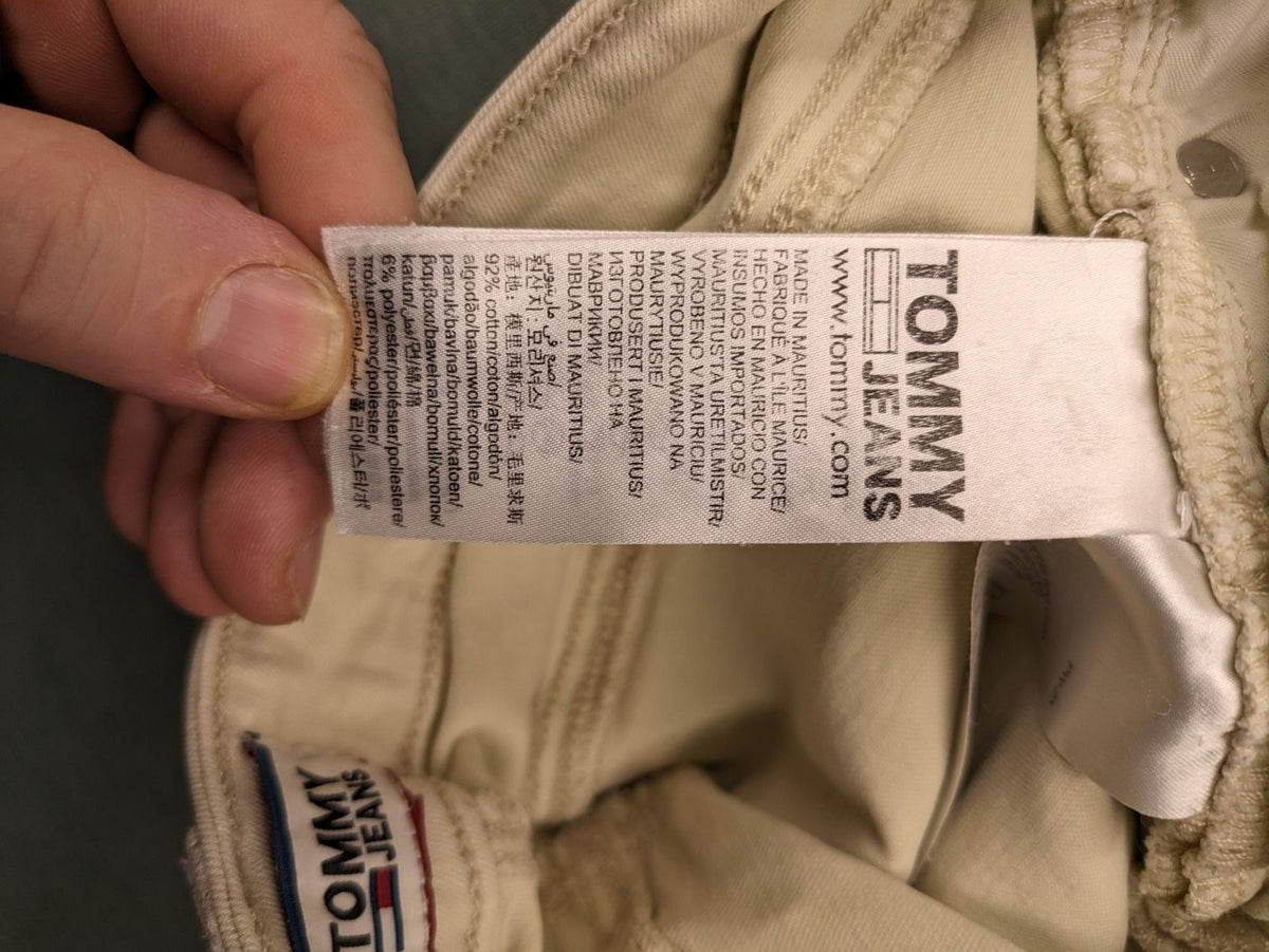 Tommy Jeans beige high rise skinny ankle jeans with logo patch and stretch fabric.
