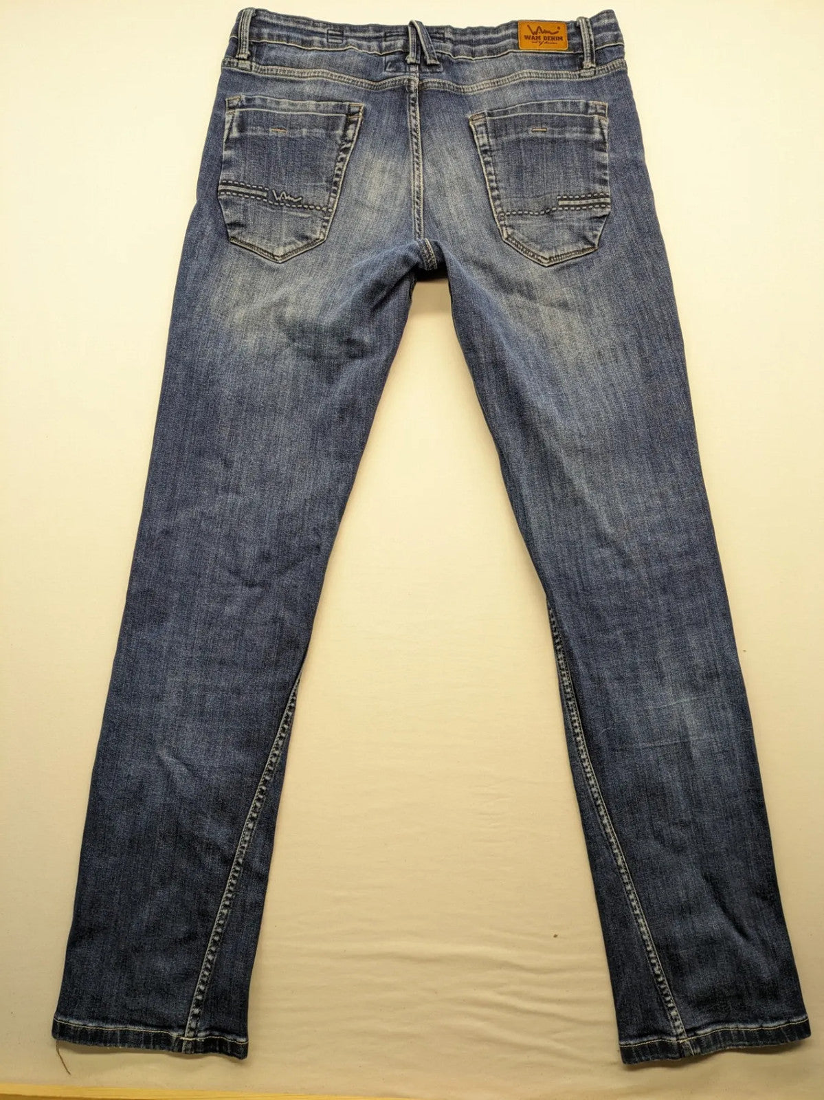 WAM Denim blue straight jeans with distressed details and button fly.
