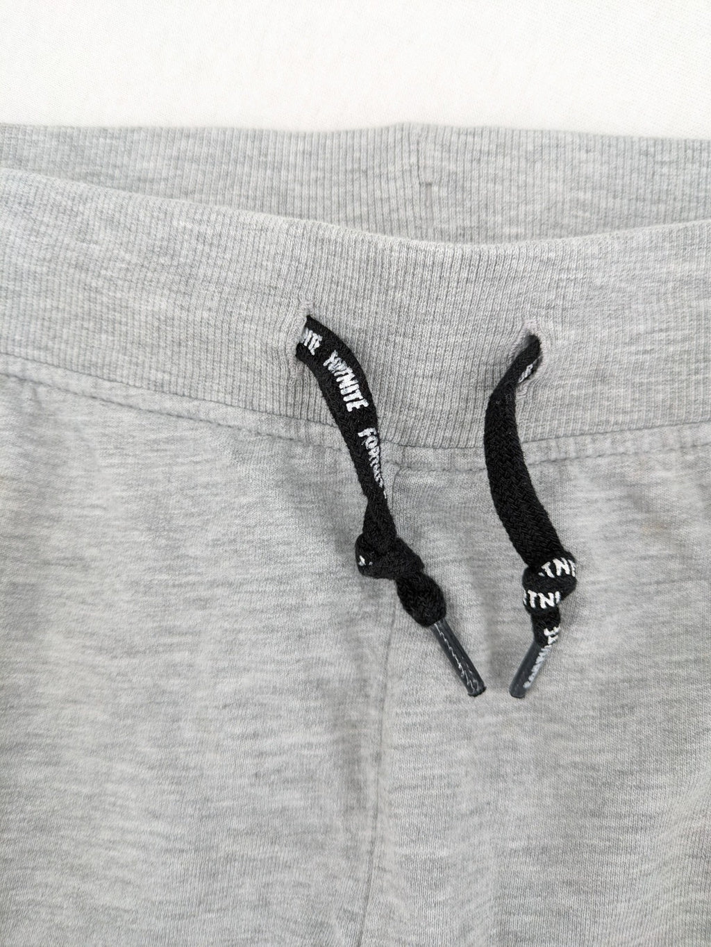 Fortnite pants grey with black side stripes and large logo print, cotton blend material.